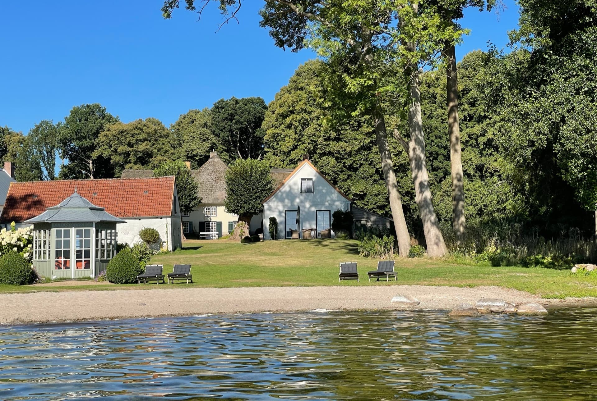 Gut Nehmten am Plöner See — Häuser am Ufer mit Liegestühlen